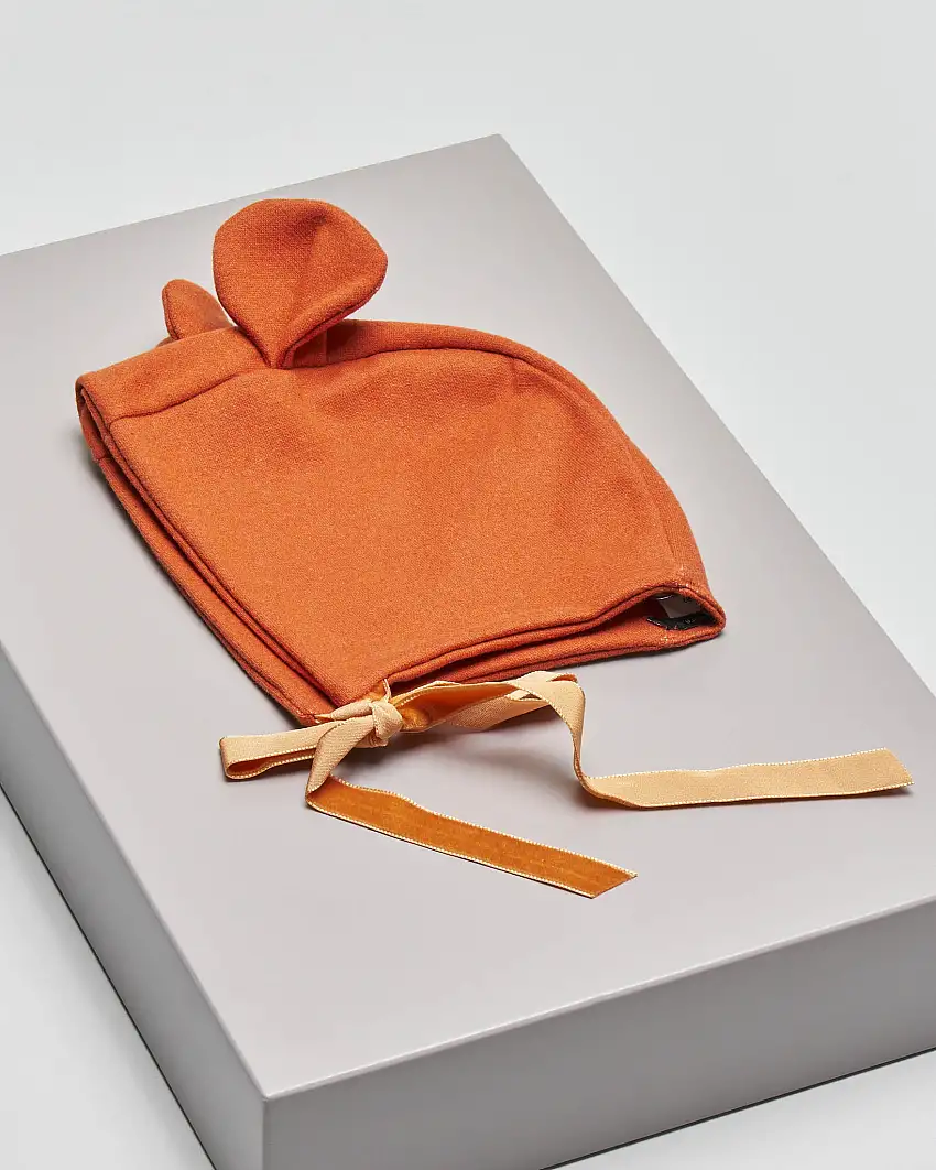 Berretto colore mattone arancio con orecchie e chiusura con nastrini 6-12 mesi